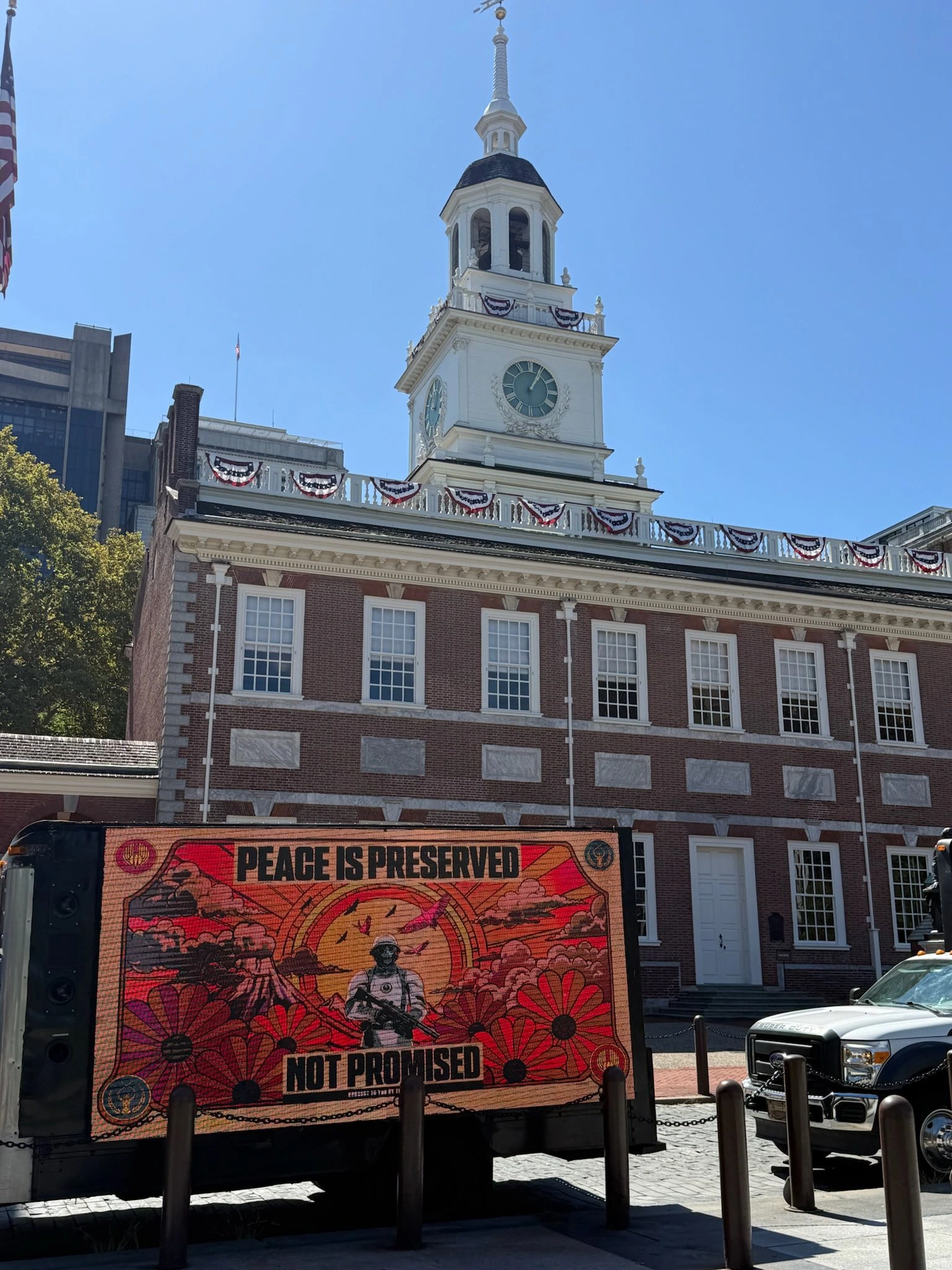 Billboard móvil de Hunger Games: Sunrise on the Reaping frente a Independence Hall con el mensaje Peace is Preserved Not Promised.