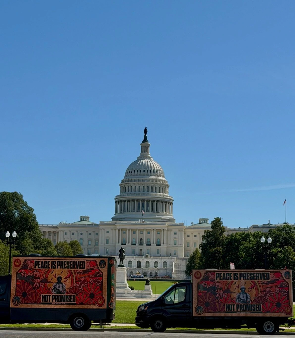 Dos billboards móviles de Hunger Games: Sunrise on the Reaping frente al Capitolio de Estados Unidos con el mensaje Peace is Preserved Not Promised.