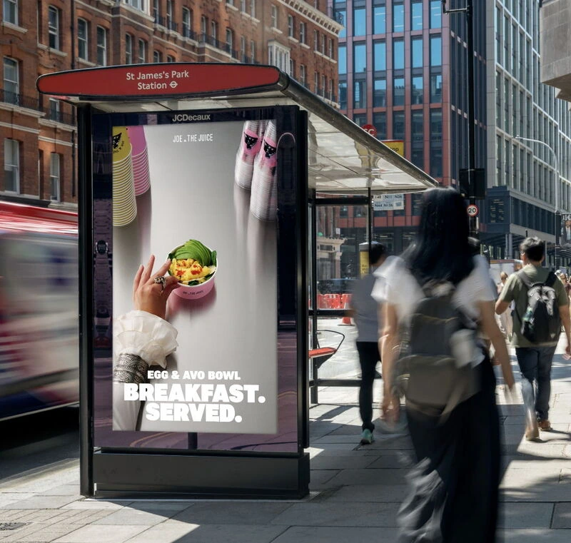 Pantalla digital de JOE & THE JUICE en Londres promocionando el Egg & Avo Bowl con el mensaje Breakfast. Served. cerca de St James's Park Station.