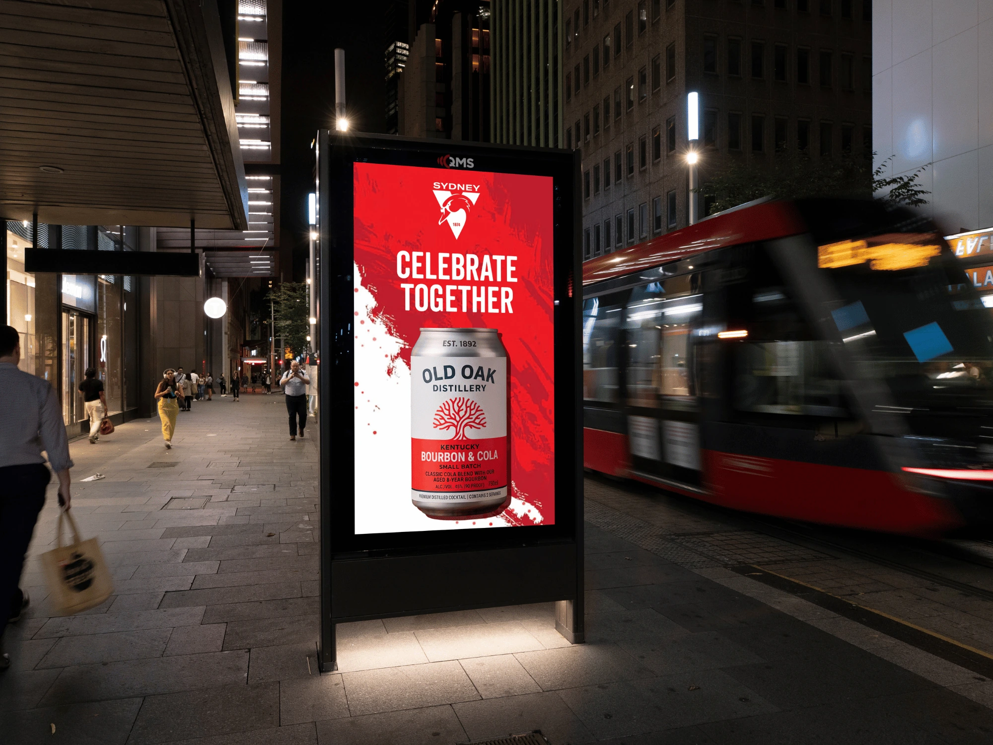 Pantalla digital nocturna de Old Oak Distillery con creatividad de Sydney y el mensaje Celebrate Together junto a transporte urbano.