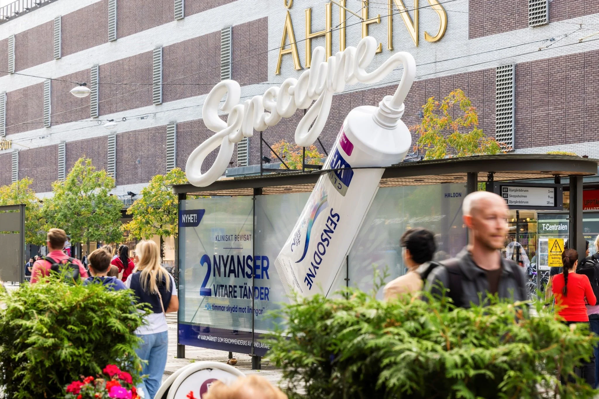 Sensodyne Clinical White special-build bus shelter in Stockholm with an oversized toothpaste tube extending above the shelter and a sculptural Sensodyne wordmark.